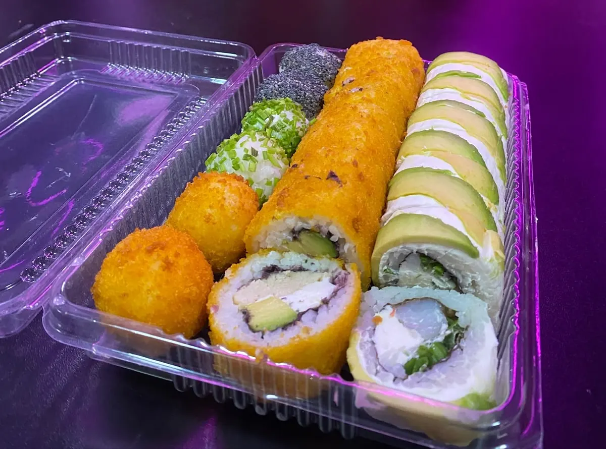 Bandeja de sushi de Mónaco con rolls envueltos en palta, rolls fritos en panko y bolitas de ciboulette y sésamo